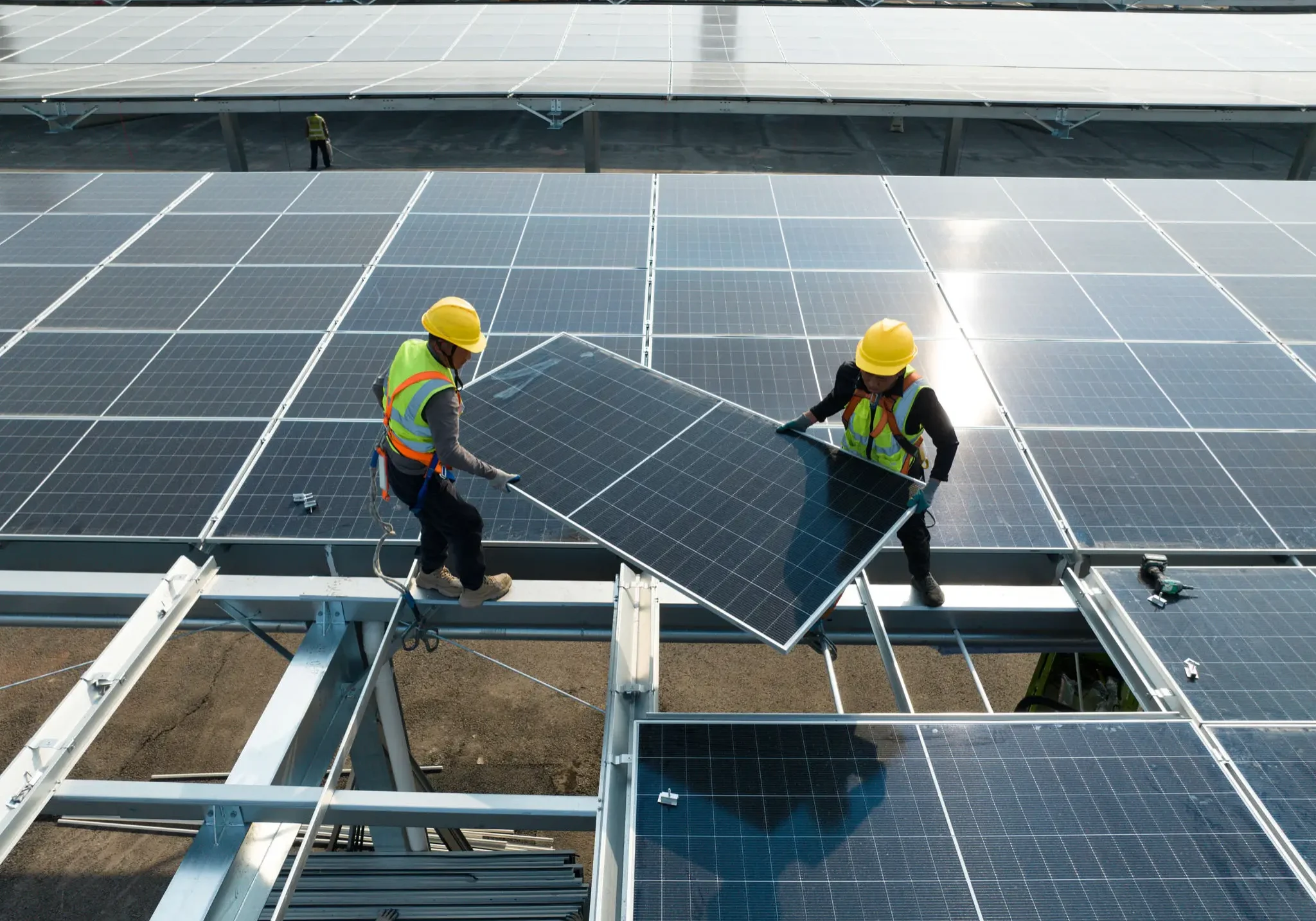 Workers installing solar panels on a rooftop.